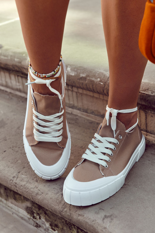 Moteriški sportbačiai ant platformos yra rudi